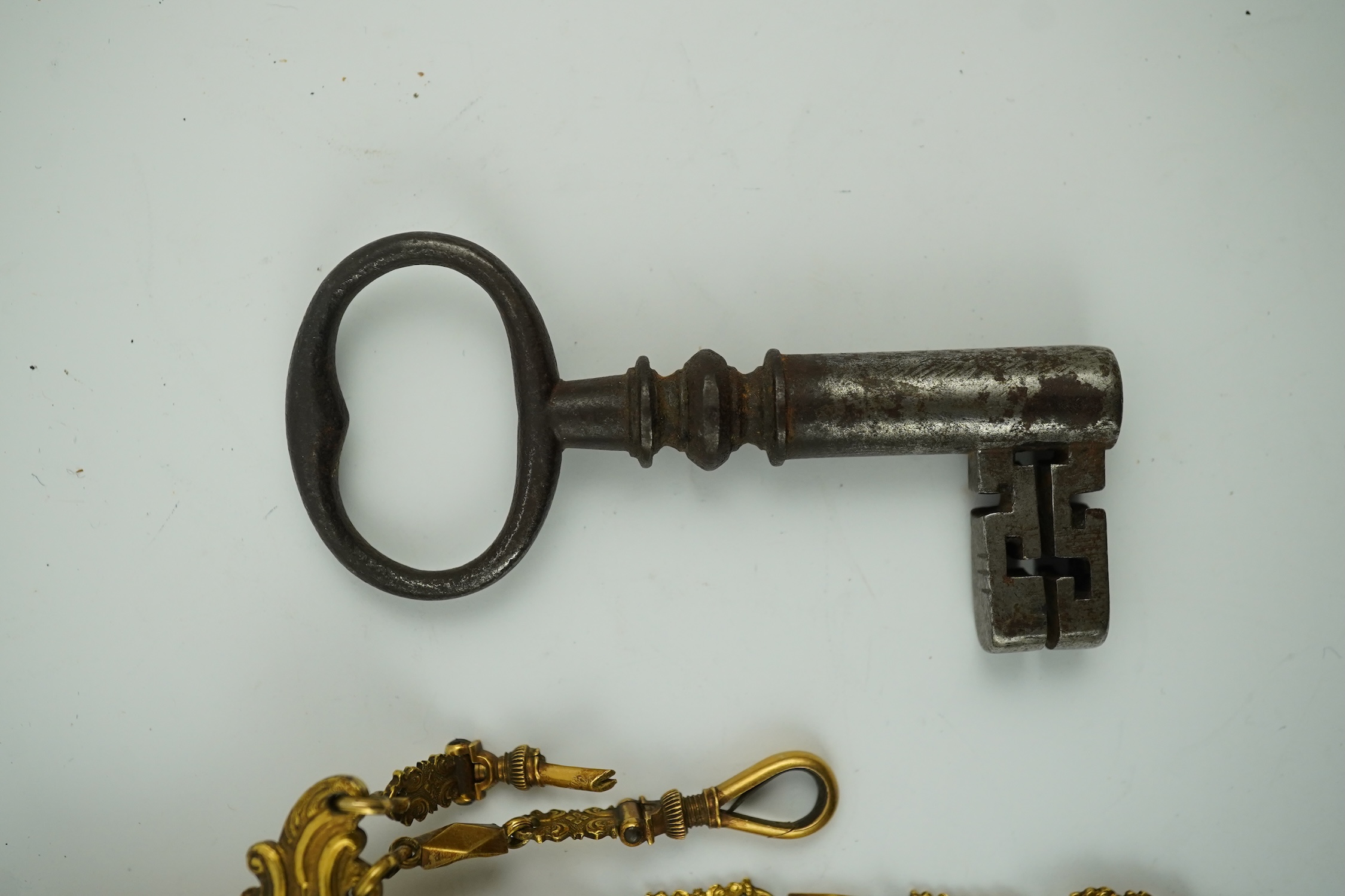 A late 18th century German gilt metal chatelaine and a steel key, chaterlaine 14cm long. Condition - a link is missing on one chain